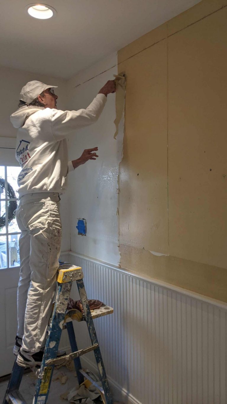 Painter removing wallpaper