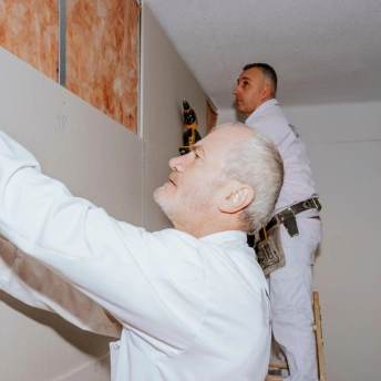 karate blackbelts installing drywall