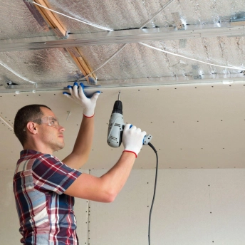 man repairing drywall ceiling