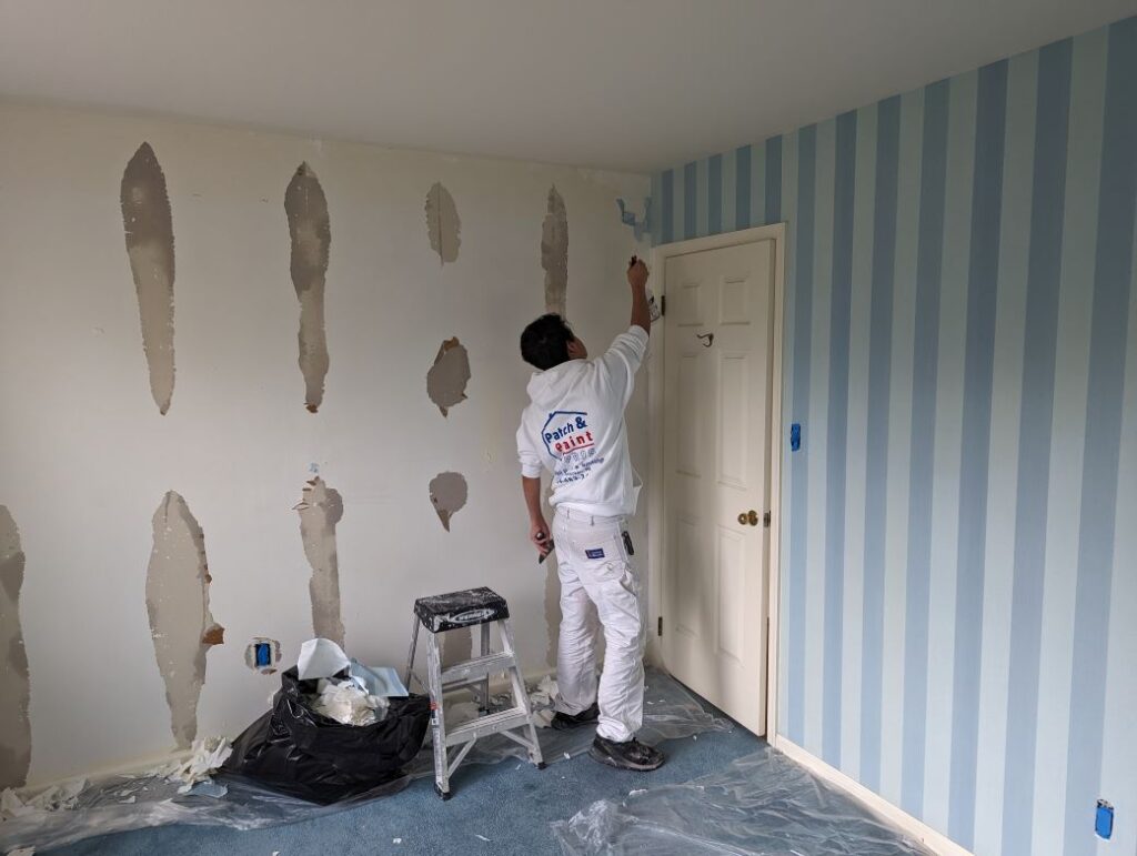 Painter removing wallpaper