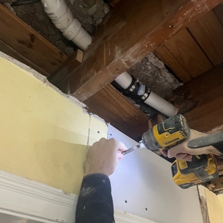 Ceiling getting repaired after plumbing leak