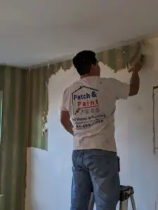Painter Removing Wallpaper in Blue Bell