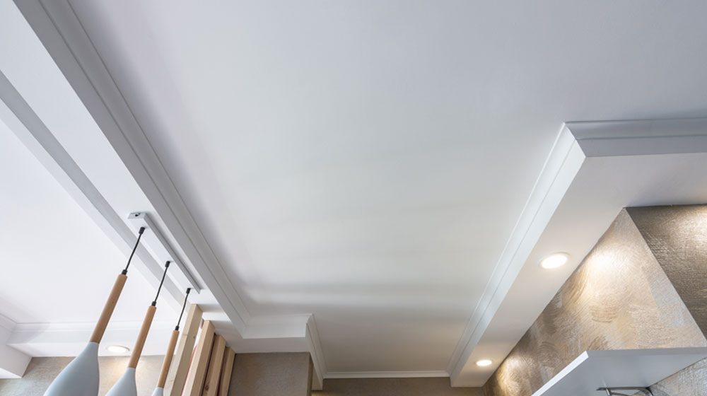 white ceiling with trim showing lighting and a modern residential decor.